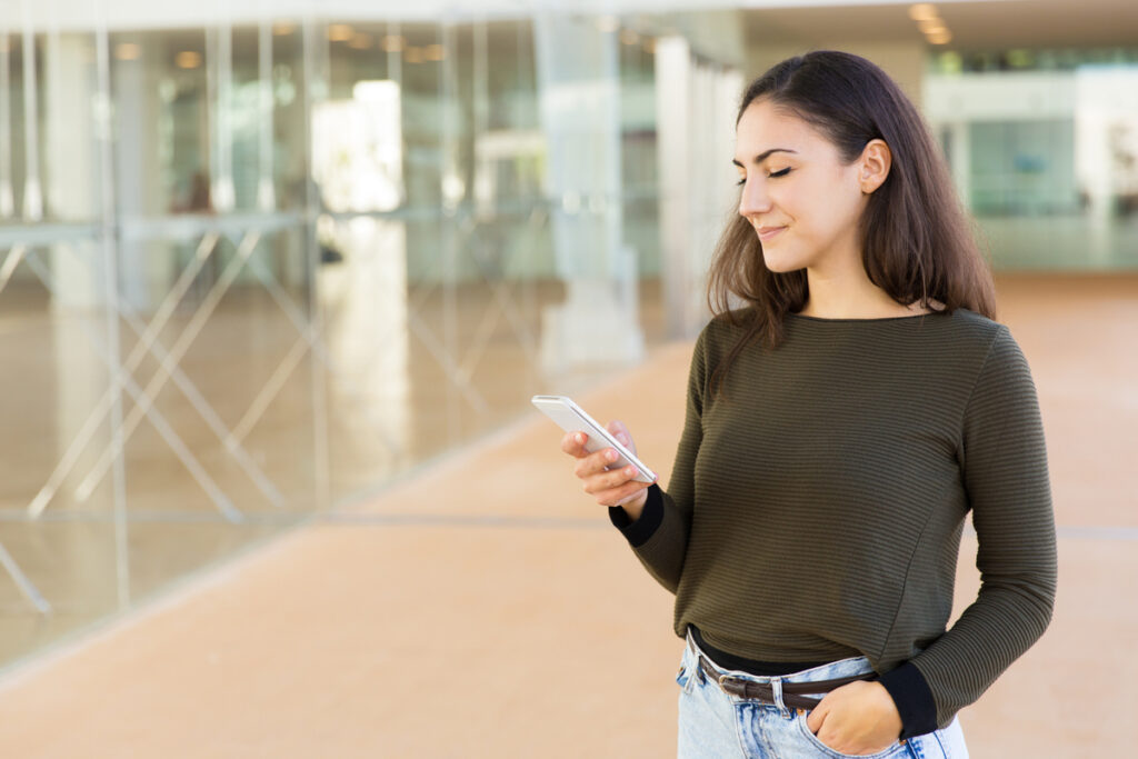 focused positive beautiful woman watching content on cellphone 1